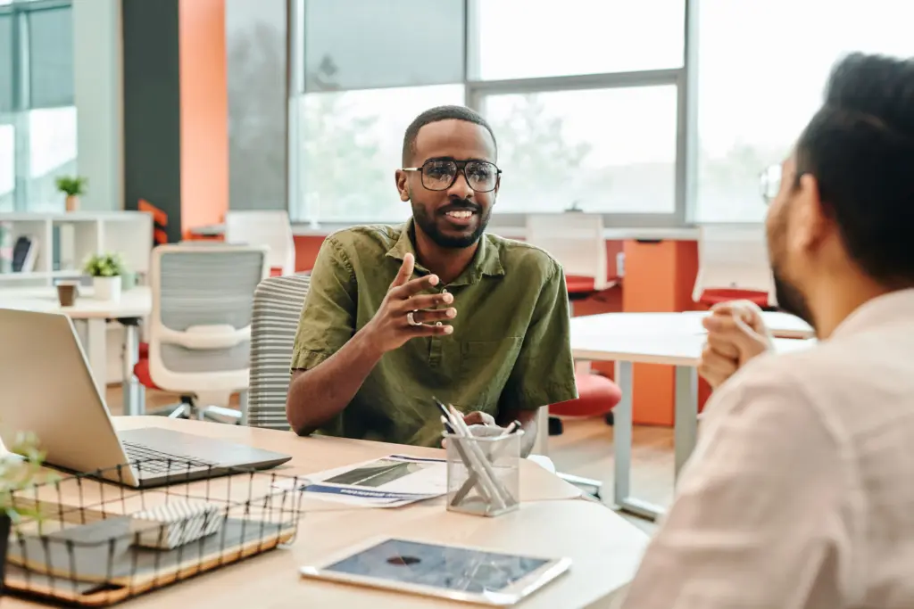 Deux personnes discutent avec bienveillance dans un cadre professionnel. Un bandeau texte indique la validation du programme PSSM par l'OCDE comme meilleure pratique